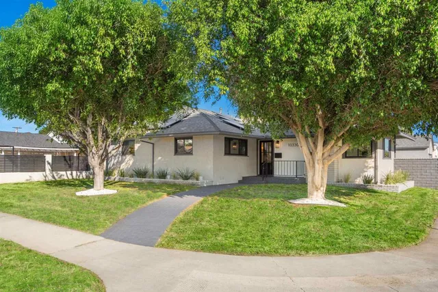a front view of a house with a yard and trees