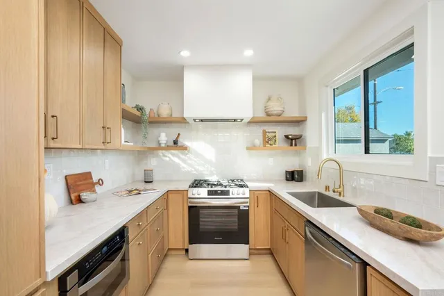 a kitchen with a sink white cabinets and white appliances