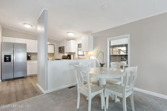 a kitchen with granite countertop white cabinets stainless steel appliances and a sink