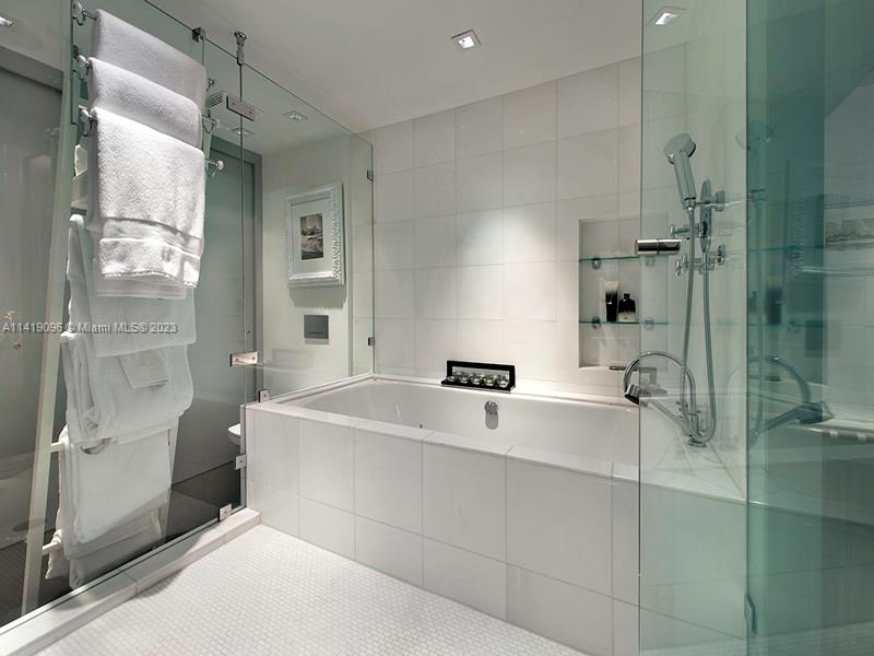 101 20th Street, Unit 2002 Miami Beach, FL 33139 - Photo 14 of 16 a spacious bathroom with a tub shower and mirror