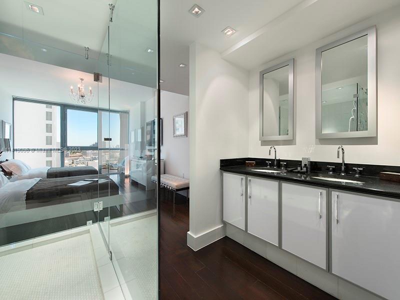 101 20th Street, Unit 2002 Miami Beach, FL 33139 - Photo 15 of 16 a bathroom with a granite countertop sink a mirror and vanity