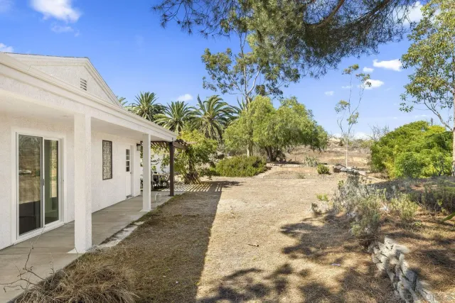 a backyard of a house with a yard and outdoor seating