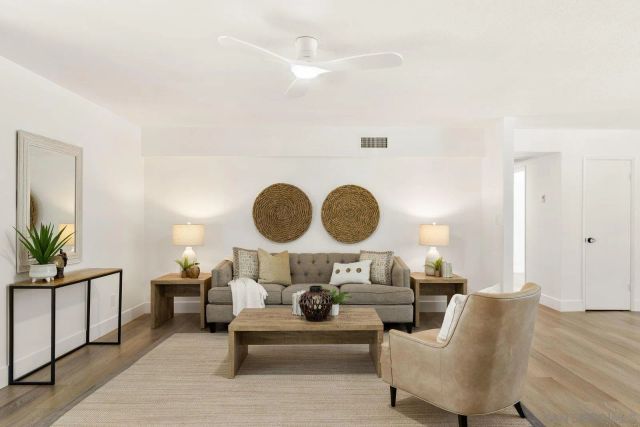 a living room with furniture and a dining table with wooden floor