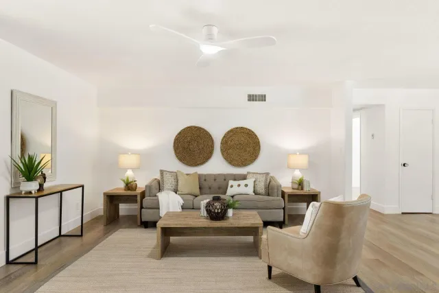 a living room with furniture and a dining table with wooden floor