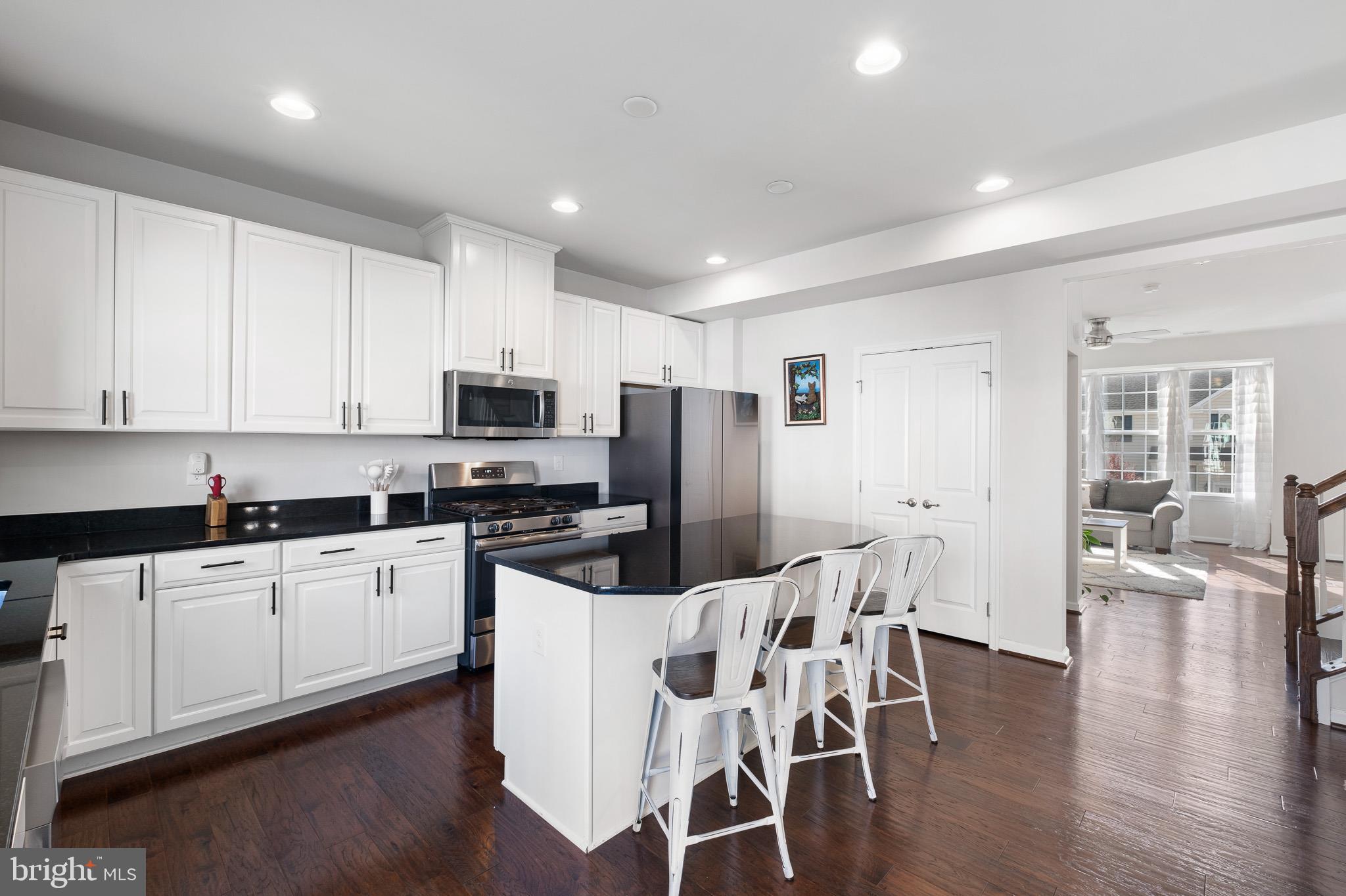 449 Smee Road Middletown, DE 19709 - Photo 12 of 31 a kitchen with stainless steel appliances granite countertop a stove top oven a sink a refrigerator with white cabinets and wooden floor