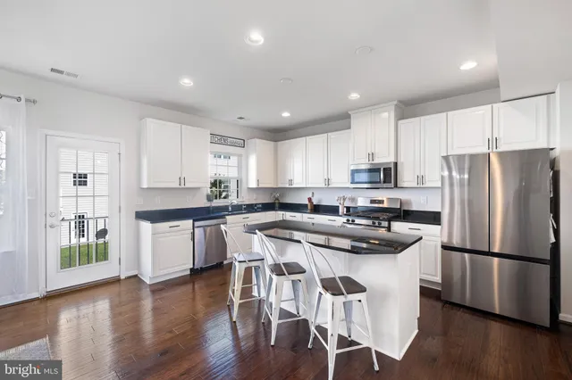 a kitchen with wooden floors and refrigerator