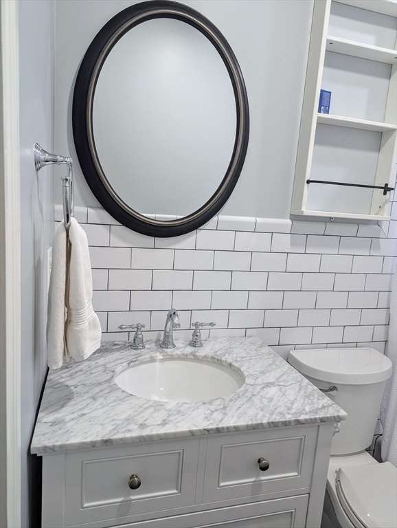 60 Day Street, Unit 1 Boston, MA 02130 - Photo 8 of 10 a bathroom with a granite countertop sink and a mirror