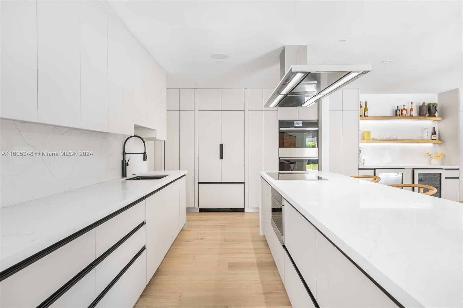9800 Southwest 70th Avenue Pinecrest, FL 33156 - Photo 14 of 46 a large white kitchen with cabinets and wooden floor