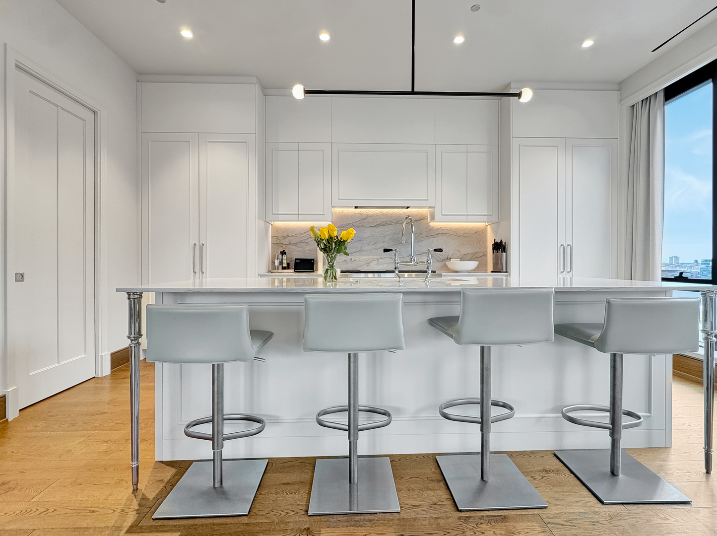 21 North May Street, Unit 802 Chicago, IL 60607 - Photo 16 of 50 a kitchen with stainless steel appliances kitchen island granite countertop a table chairs in it and wooden floors