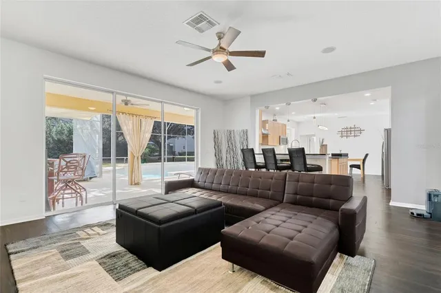 a kitchen with stainless steel appliances kitchen island granite countertop a table chairs and a refrigerator