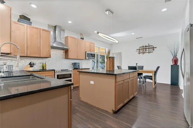 a kitchen with granite countertop a sink a stove and cabinets