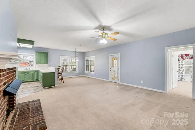an empty room with windows and ceiling fan