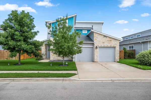 a front view of a house with a yard and a garage