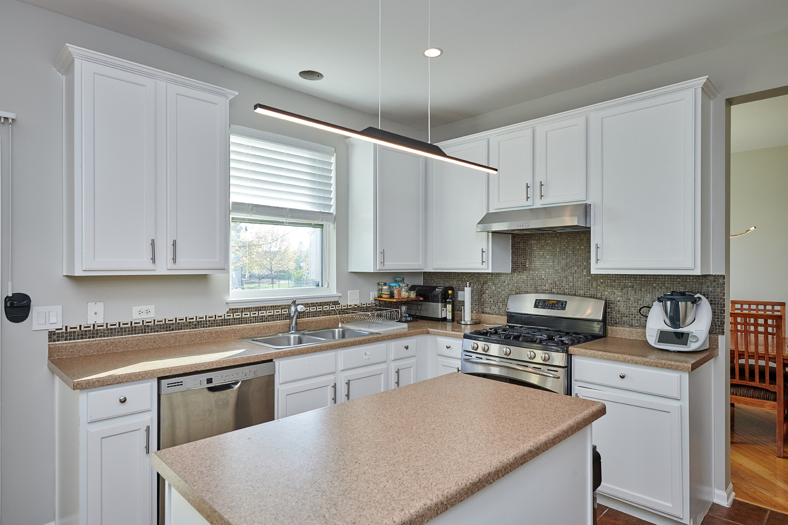 312 Shelbourne Road Volo, IL 60073 - Photo 36 of 54 a kitchen with kitchen island granite countertop a sink a stove a counter space and cabinets