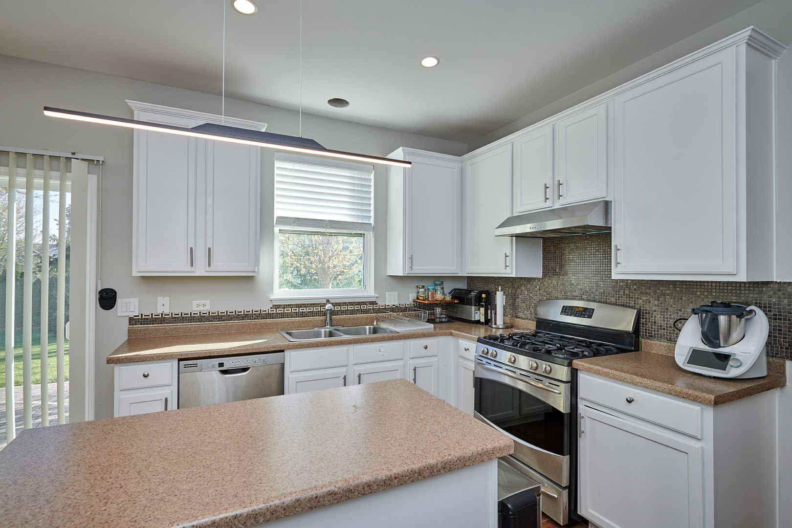 312 Shelbourne Road Volo, IL 60073 - Photo 37 of 54 a kitchen with kitchen island granite countertop a sink cabinets and window