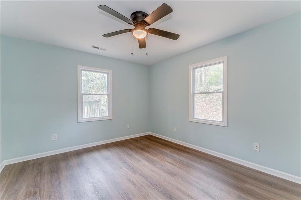 43 King Bee Circle Rome, GA 30161 - Photo 19 of 47 an empty room with wooden floor ceiling fan and windows