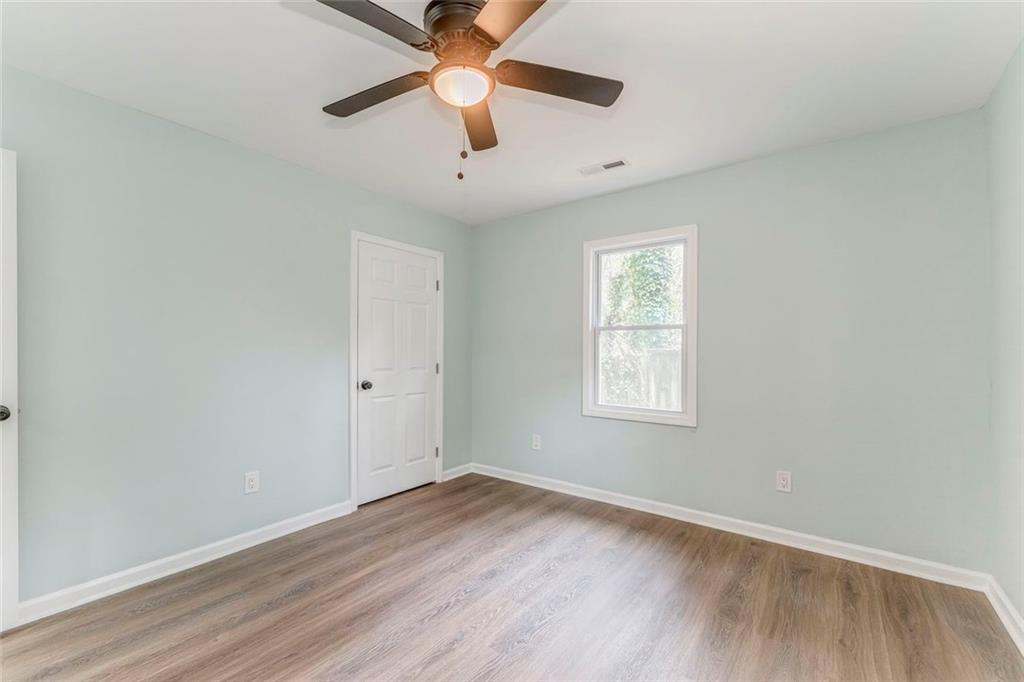 43 King Bee Circle Rome, GA 30161 - Photo 21 of 47 an empty room with wooden floor ceiling fan and windows