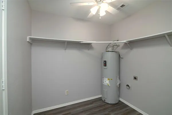 a view of an empty room with wooden floor and cabinet