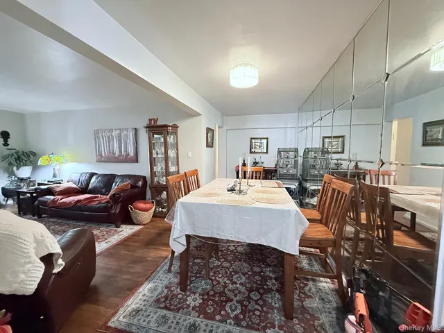 a living room with furniture a rug kitchen view and a table