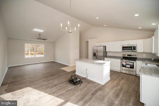 2 Spicers Mill Road Orange, VA 22960 - Photo 9 of 46 a kitchen with stainless steel appliances kitchen island granite countertop a stove a sink a refrigerator and white cabinets with wooden floor
