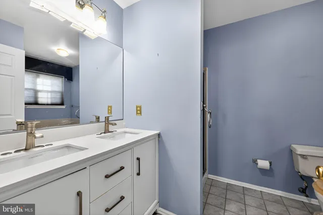 a bathroom with a sink a toilet and a mirror