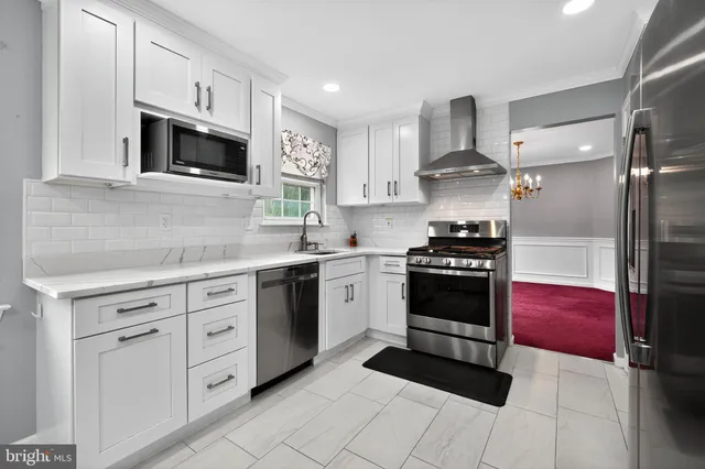 a kitchen with cabinets stainless steel appliances and sink