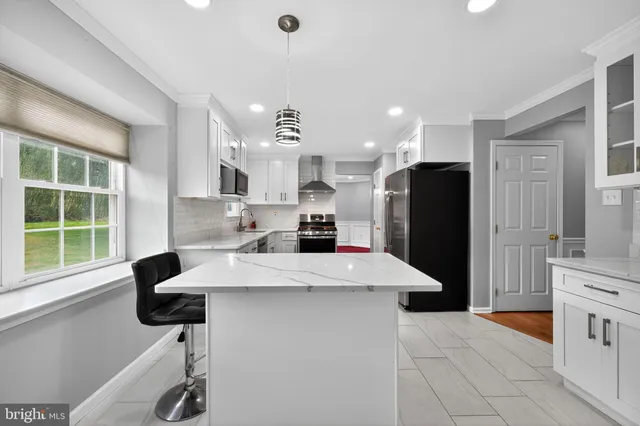 a kitchen with stainless steel appliances kitchen island granite countertop a refrigerator a sink a stove and a cabinets