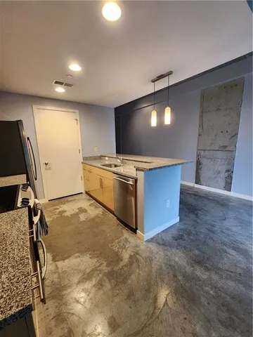 a large kitchen with stainless steel appliances a large counter top