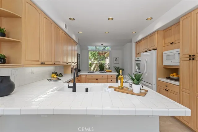 a kitchen with kitchen island a large counter top space a sink stainless steel appliances and cabinets
