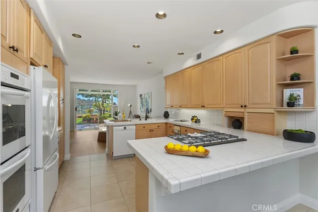 a kitchen with a sink a stove and chairs