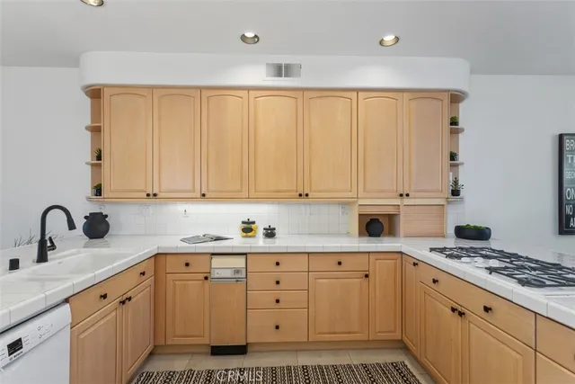 a kitchen with granite countertop a sink stove and cabinets