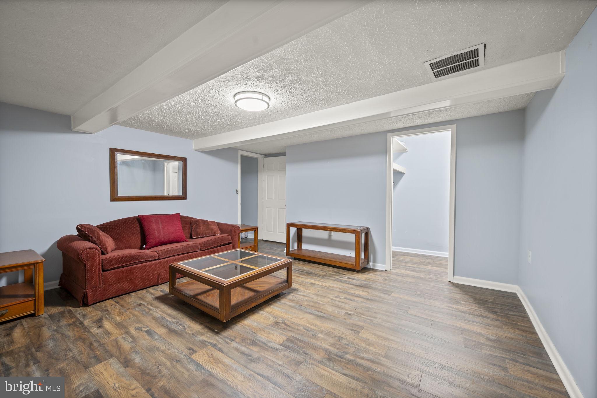 10412 Vincent Road White Marsh, MD 21162 - Photo 33 of 65 a living room with furniture a flat screen tv and a wooden floor