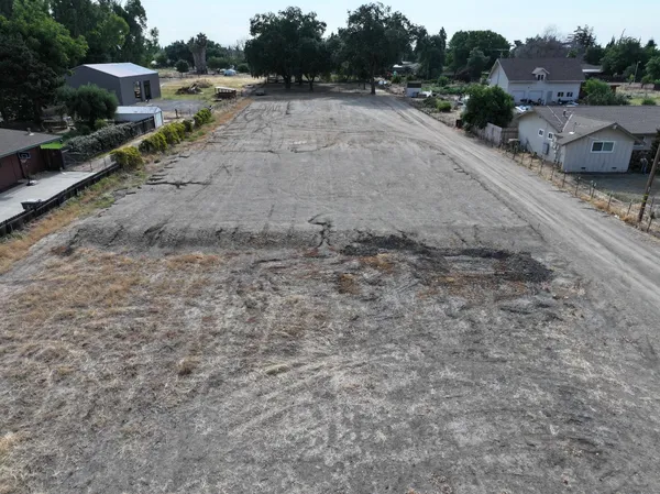 a view of a dry yard with wooden fence
