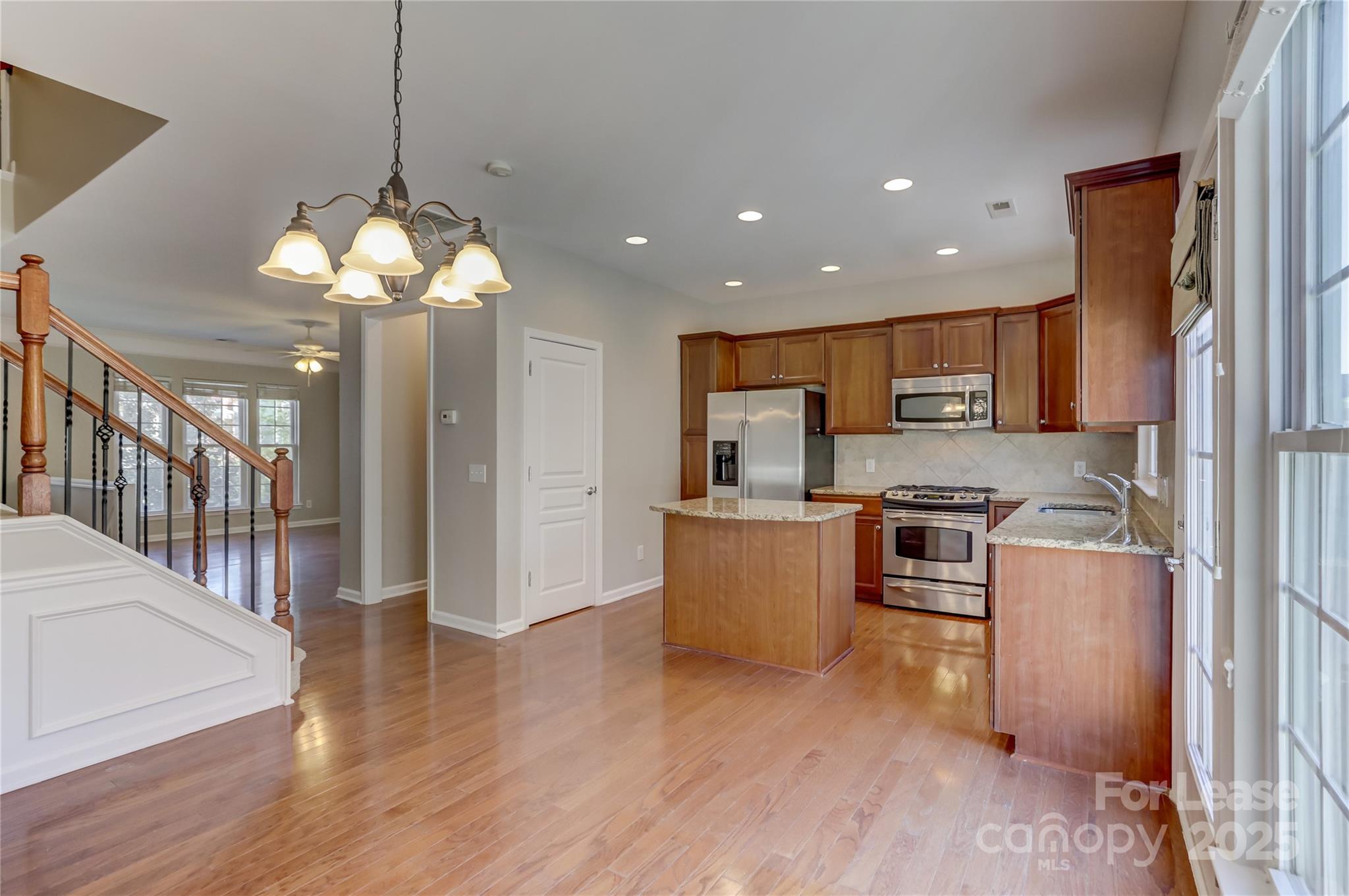 562 6th Baxter Crossing Fort Mill, SC 29708 - Photo 20 of 47 a open kitchen with stainless steel appliances granite countertop a refrigerator a stove top oven a sink dishwasher and wooden floor