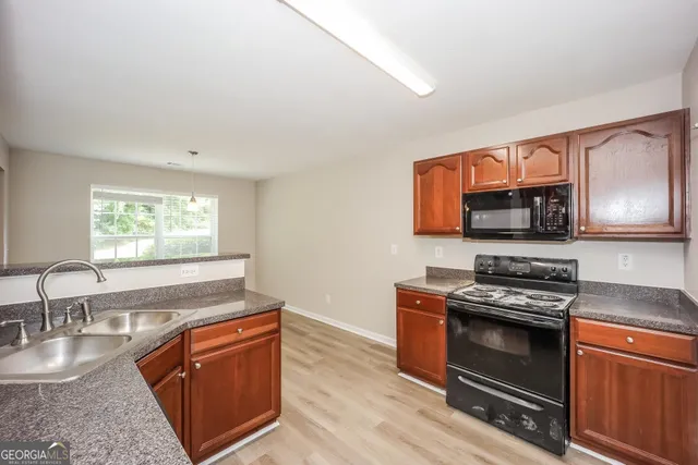 a kitchen with stainless steel appliances granite countertop a stove a sink and a microwave