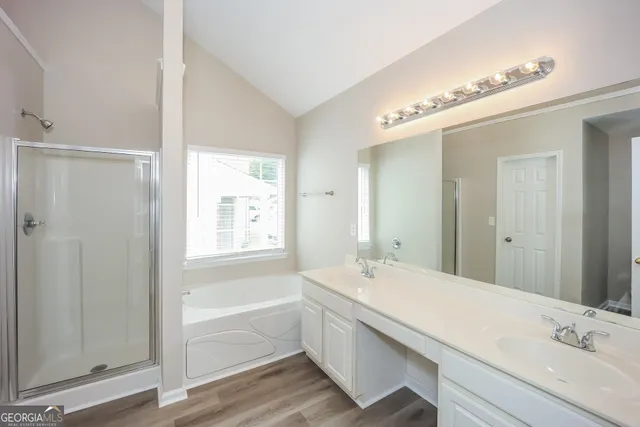 a bathroom with a tub a sink and a large mirror