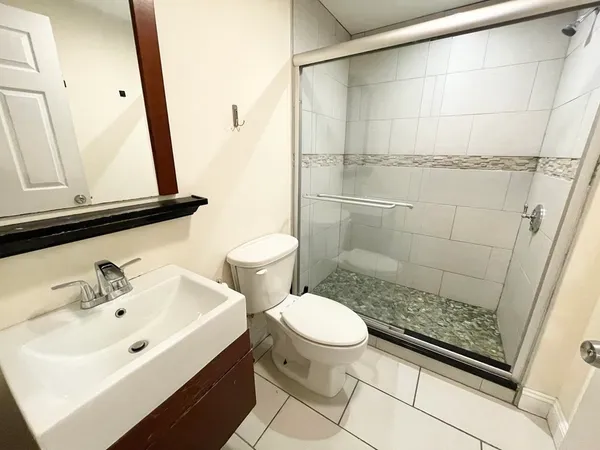 a bathroom with a sink a toilet and shower