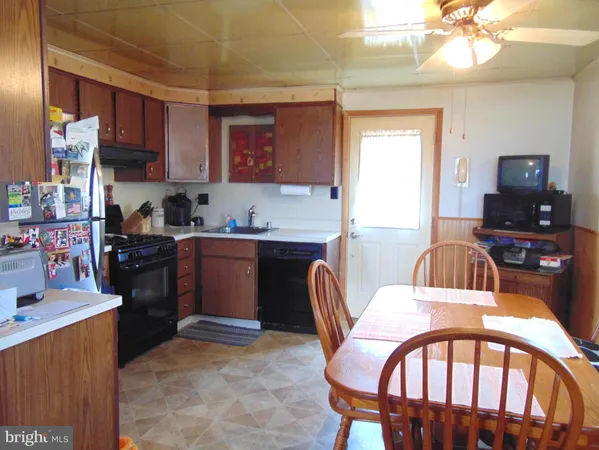 a kitchen with a dining table chairs and a refrigerator