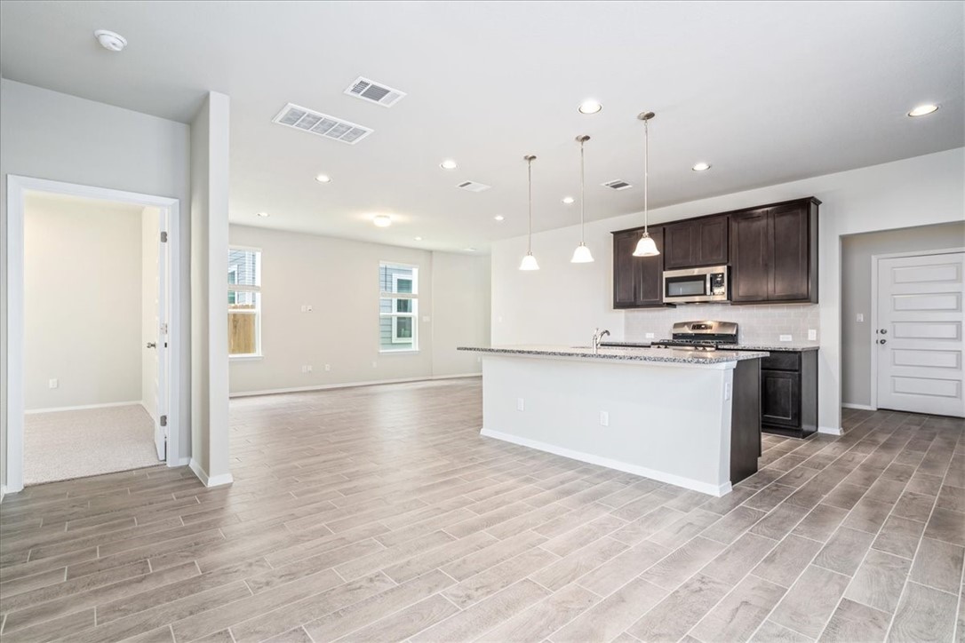 169 Heather Glen Way Maxwell, TX 78656 - Photo 16 of 40 a view of kitchen with granite countertop stainless steel appliances refrigerator oven stove microwave and cabinets