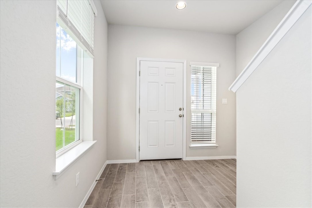 169 Heather Glen Way Maxwell, TX 78656 - Photo 6 of 40 a view of an empty room with a window and wooden floor