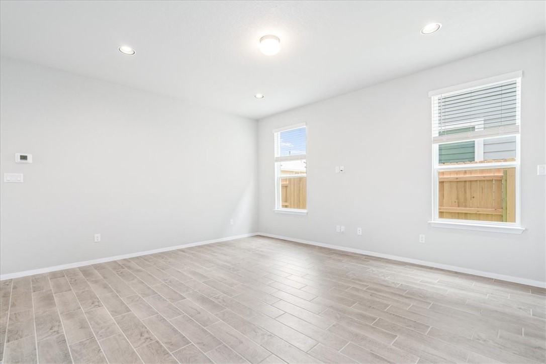 169 Heather Glen Way Maxwell, TX 78656 - Photo 9 of 40 an empty room with wooden floor and windows