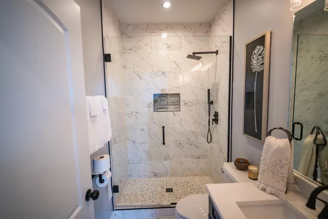 a bathroom with a sink a toilet and shower