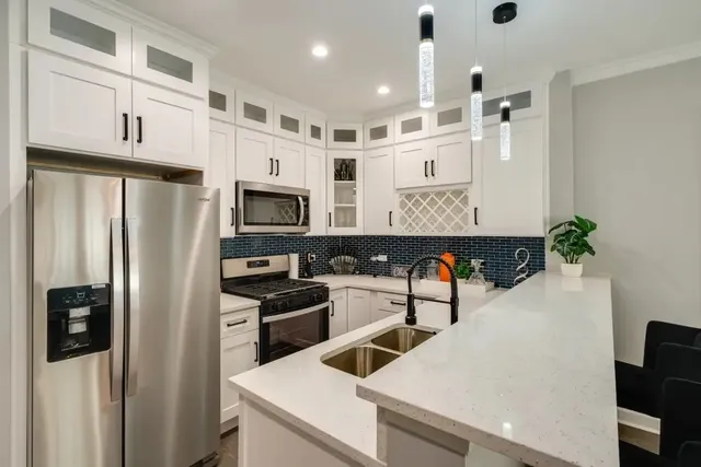 a kitchen with stainless steel appliances kitchen island granite countertop a refrigerator and a stove top oven