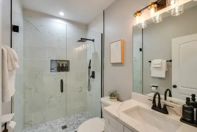 a bathroom with a sink a toilet and shower