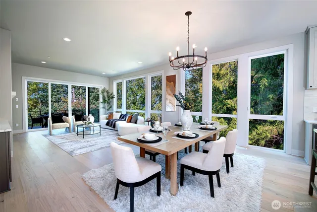 a dining room with wooden floor a chandelier a glass table and chairs