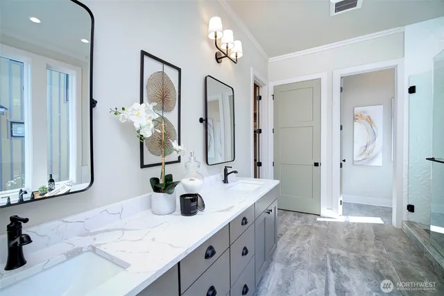 a bathroom with a double vanity sink mirror and shower