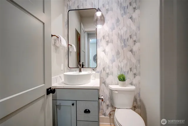 a bathroom with a sink and mirror with toilet