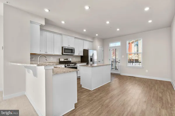 a kitchen with stainless steel appliances granite countertop a stove top oven a refrigerator a sink and dishwasher