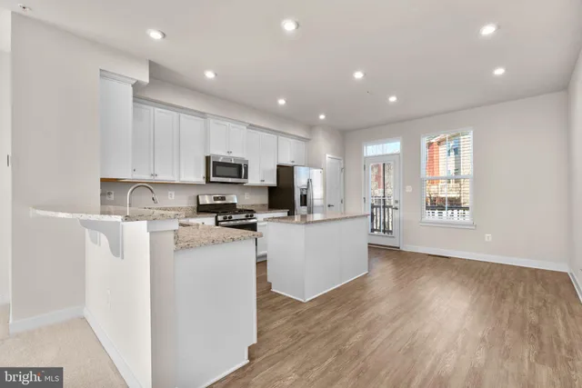 a kitchen with stainless steel appliances granite countertop a stove top oven a refrigerator a sink and dishwasher