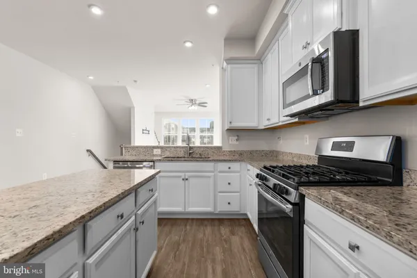 a kitchen with granite countertop white cabinets and white appliances